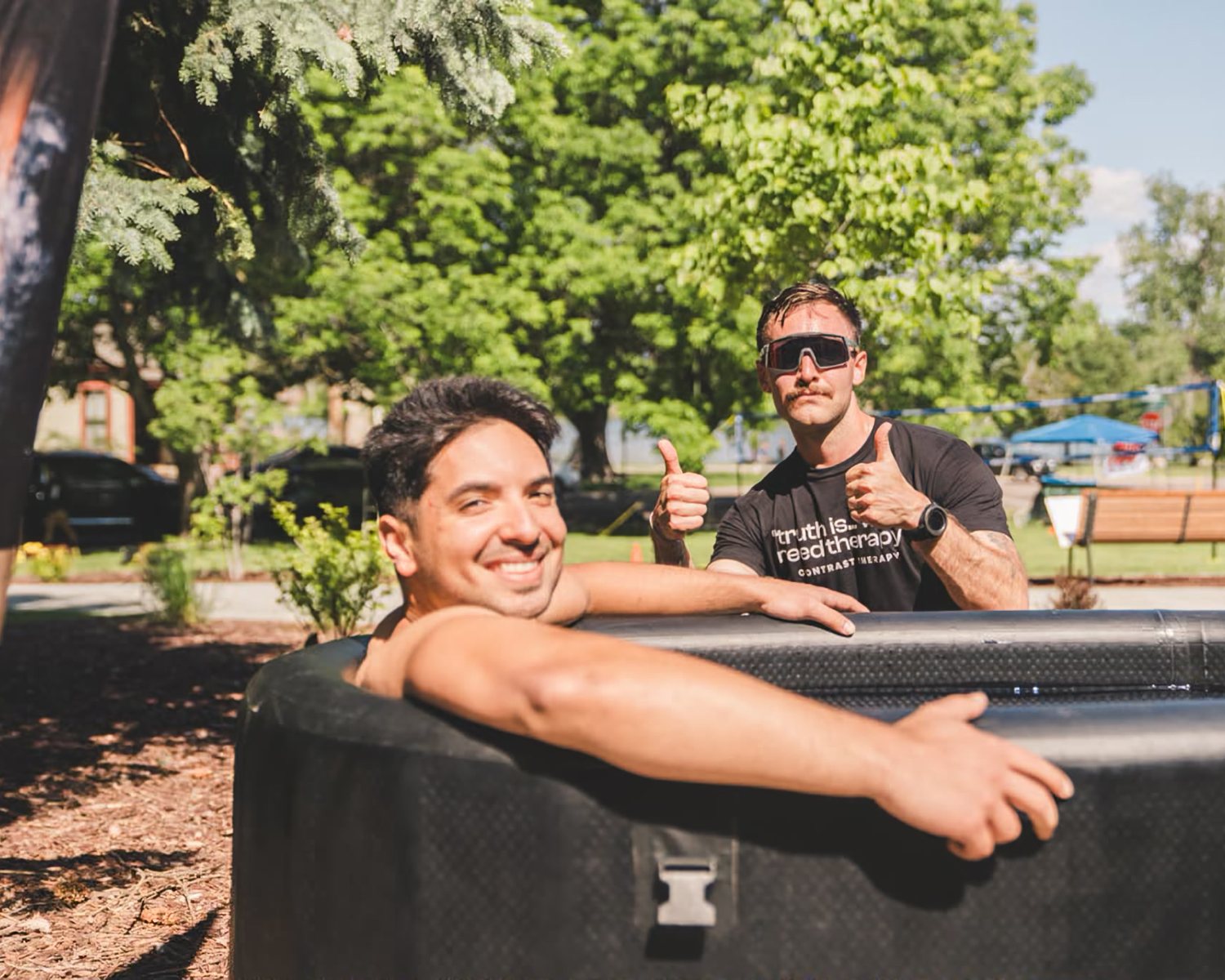 Two people in the cold plunge tub at an RWC Denver event