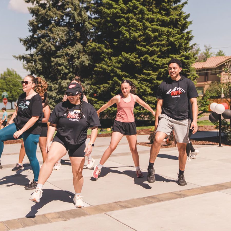 A fitness class mid-jump on the pavement outside