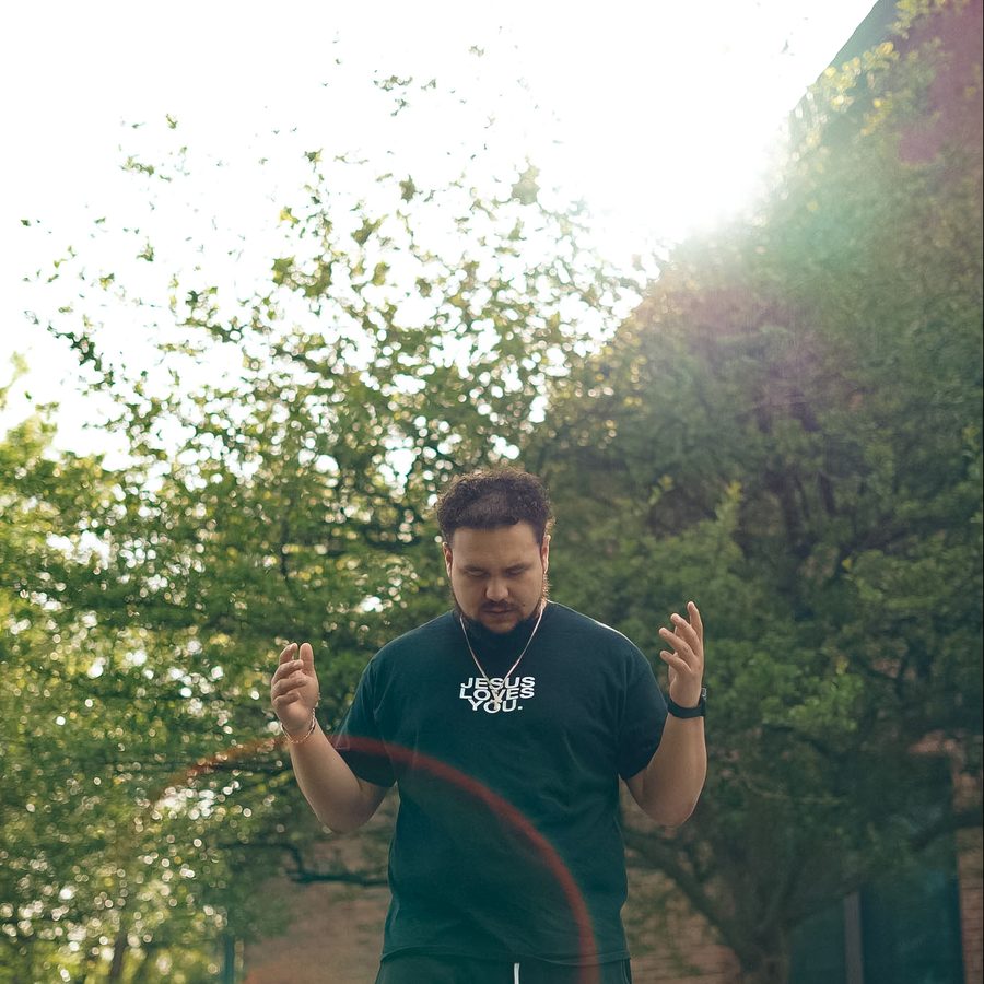 A man standing with open hands in the morning sun