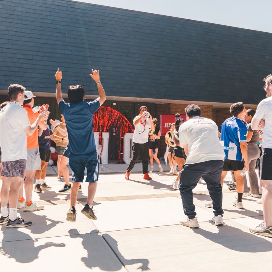 The crowd with hands in the air outside the building