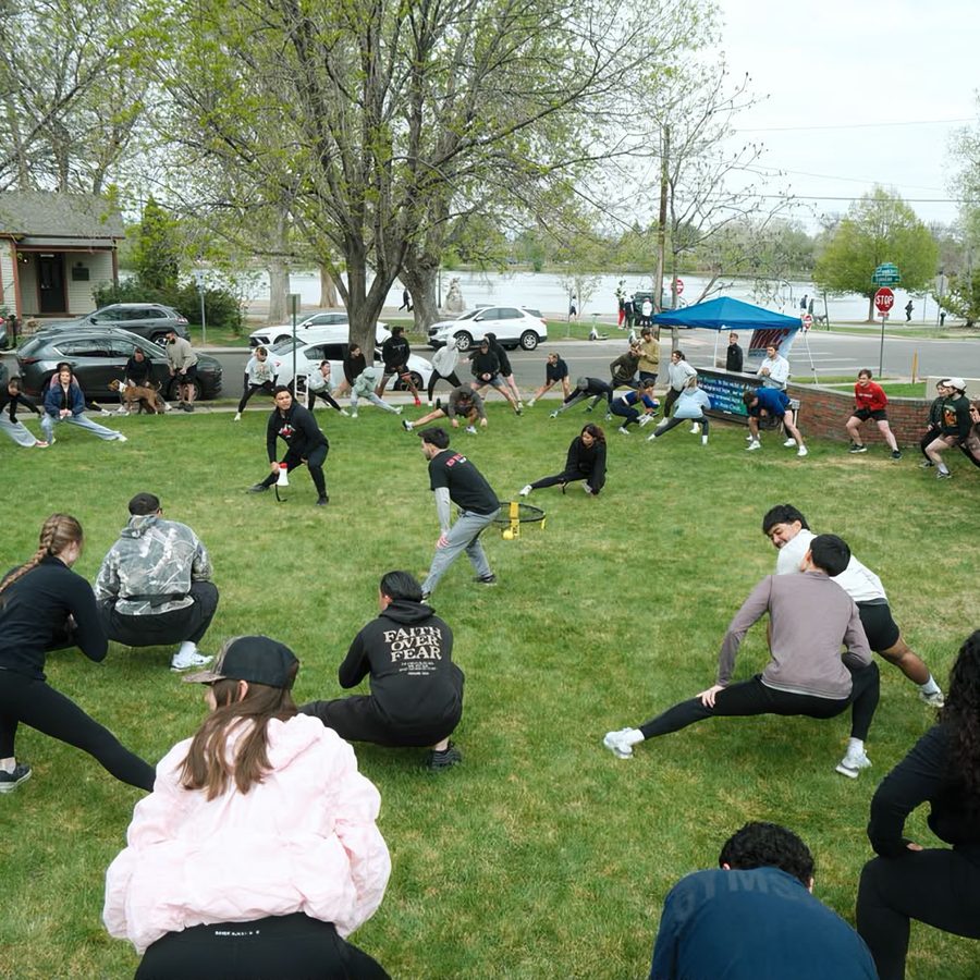 The group spread across the grass warming up before a run