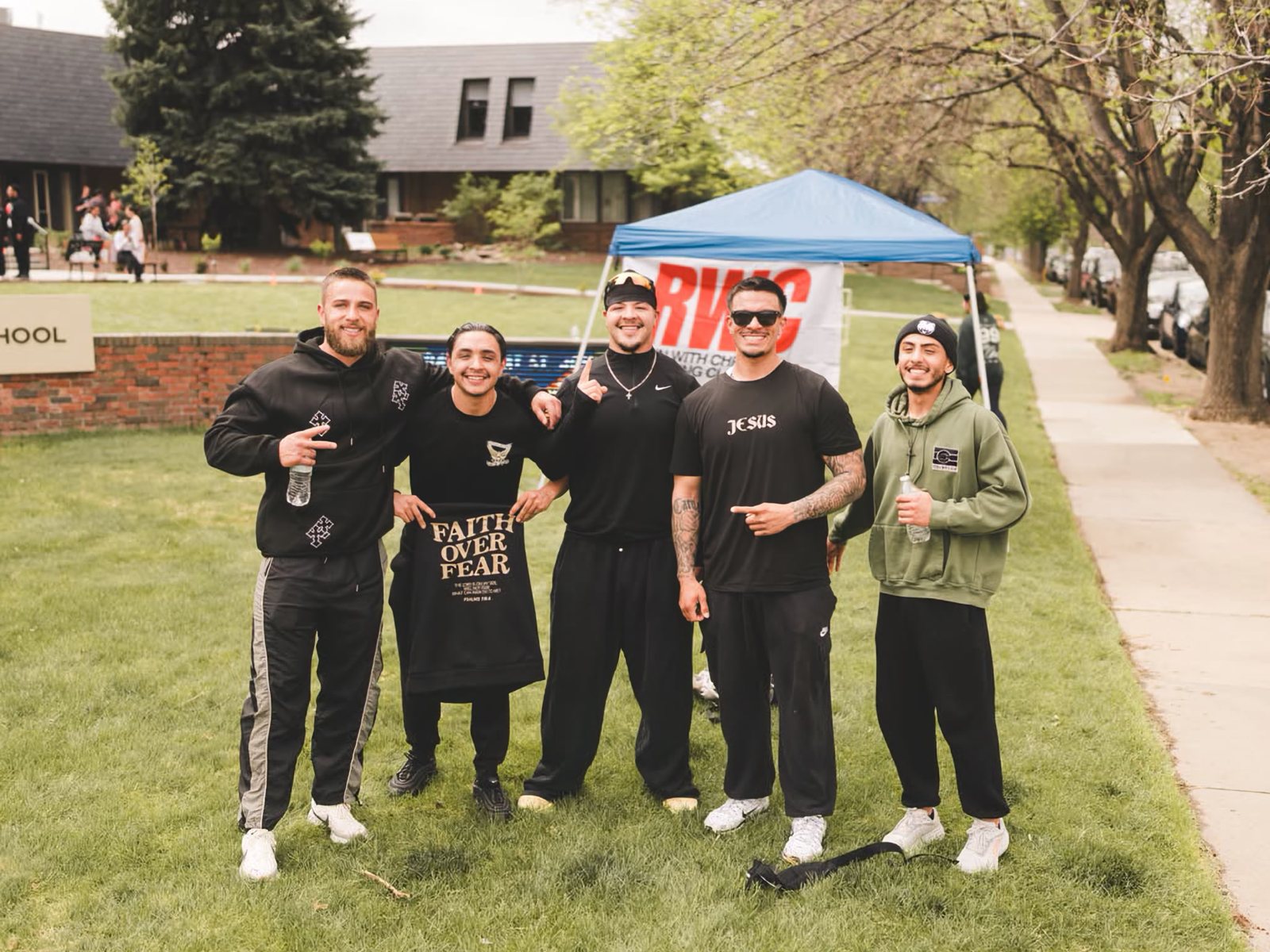 The RWC Denver tent set up on the grass with the team in front of it